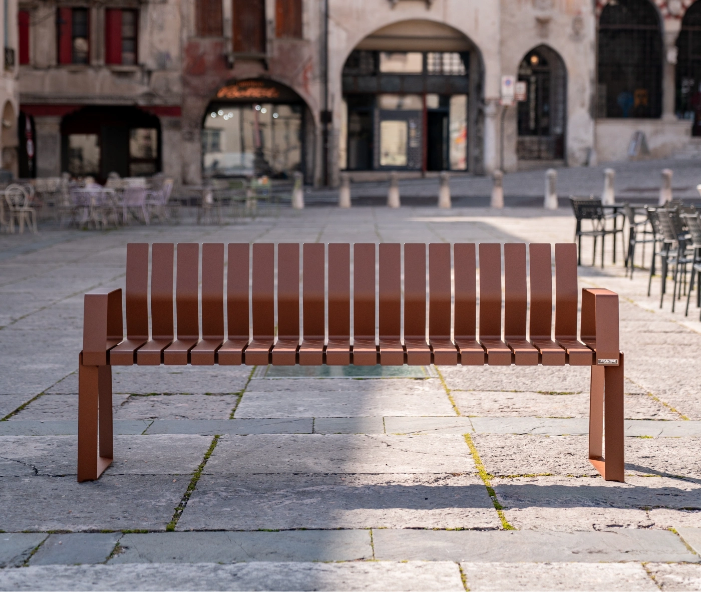 Urbantime Liberty.080 outdoor slat bench in front view set in an urban plaza.