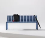 Urbantime Liberty.080 blue outdoor bench shown in a studio setting with everyday carry items