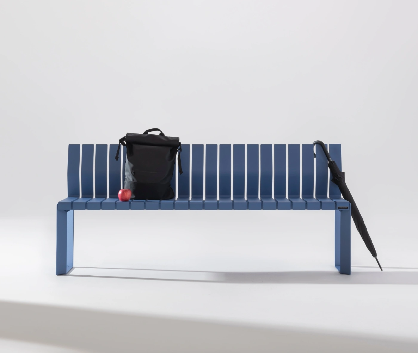 Urbantime Liberty.080 blue outdoor bench shown in a studio setting with everyday carry items