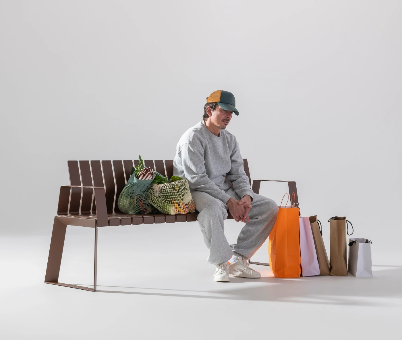 Urbantime Liberty.080 outdoor bench in a contemporary setting with shopping items.