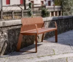 Urbantime Liberty.080 outdoor slat bench in front-right view set in an urban plaza.