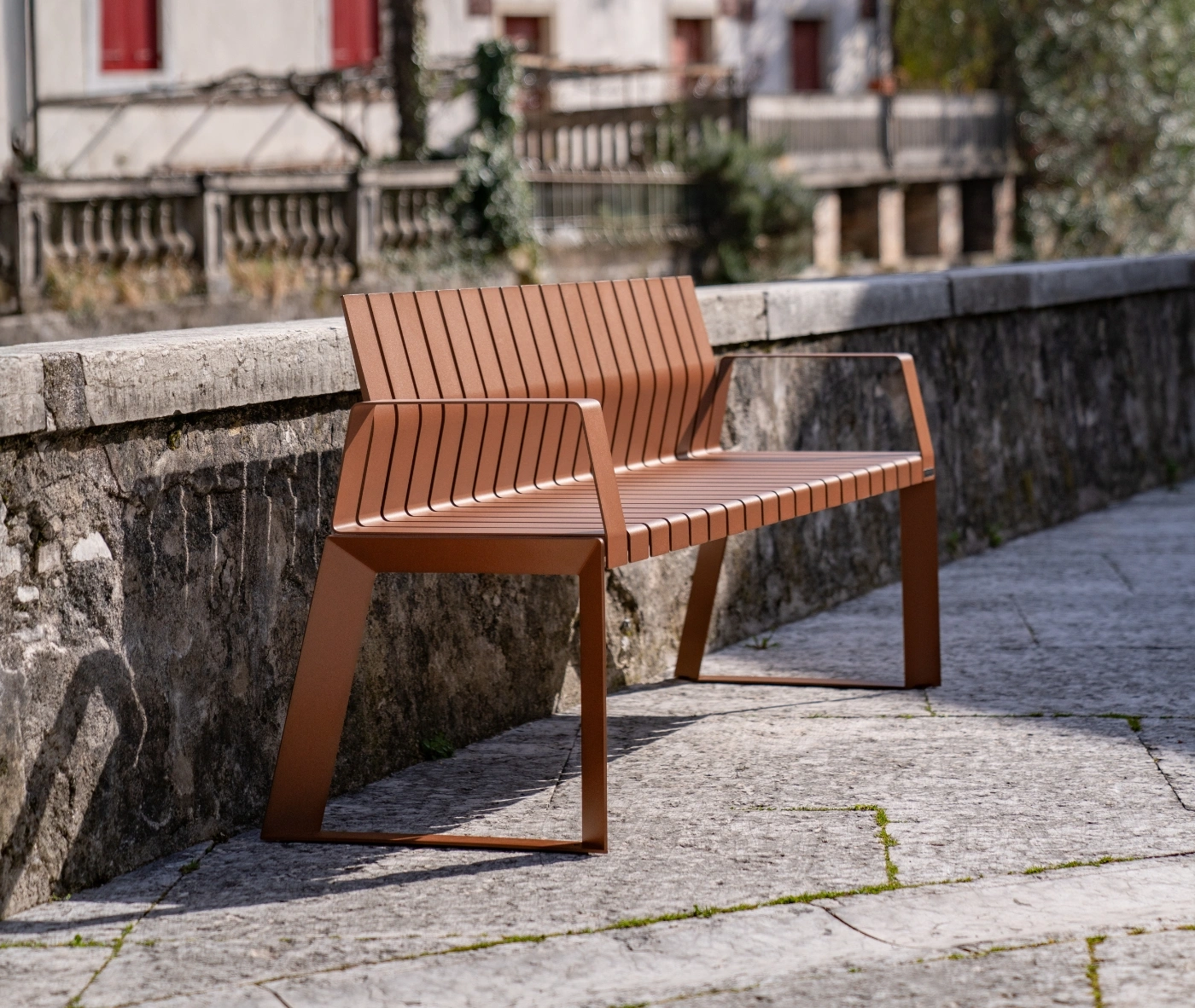 Urbantime Liberty.080 outdoor slat bench in front-right view set in an urban plaza.