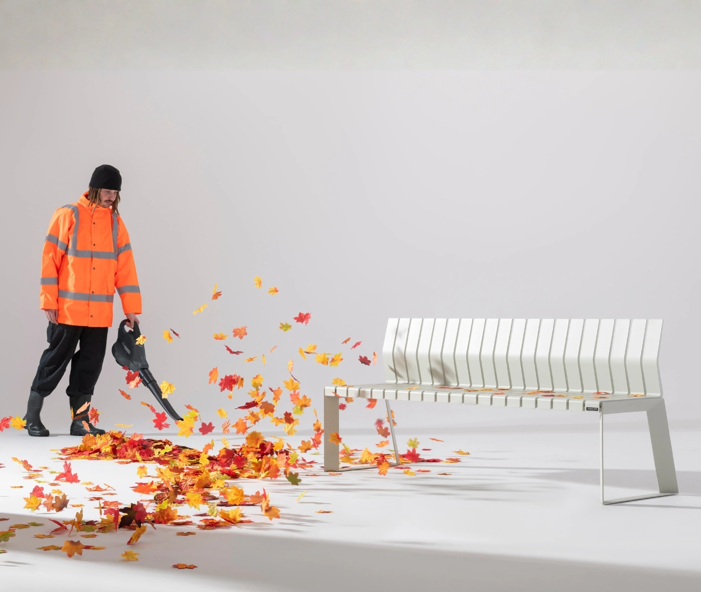 Urbantime Liberty.080 white outdoor bench bench shown studio setting with autumn leaf-blowing interaction.