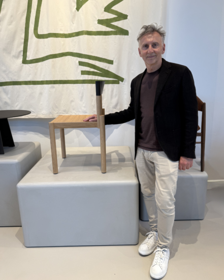 Designer Leonardo Rossano beside the True Adinne chair in a showroom setting.