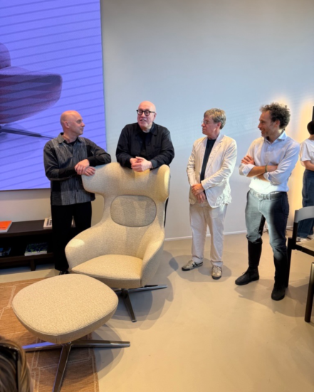 True Ahkka lounge chair and ottoman presented in a contemporary showroom setting with designers and guests.