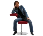 Bla Station Innovation C chair in red upholstery, with a person using the lower section as a seat and the upper curve as a backrest.