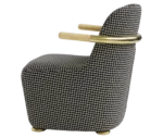 Bla Station Jackson lounge chair in left-side view, upholstered in patterned fabric with a curved backrest and timber armrests.
