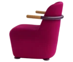 Bla Station Jackson lounge chair in left side view in pink upholstery with curved backrest and timber armrests.
