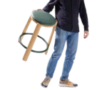 True Cute stool shown carried by a person, with its timber frame and circular footrest.