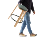 True Cute stool shown being carried by a person, highlighting its lightweight design and timber frame.