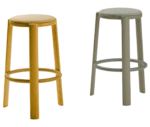 True Cute stools, front view with tall timber legs, upholstered seats and circular footrests in mustard and grey finishes.