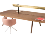 Close-up of True Wing Library table with long dark timber tabletop, integrated brass reading lamp and workspace accessories.